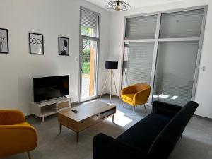 uma sala de estar com um sofá e uma televisão em Solesmes 72 em Solesmes