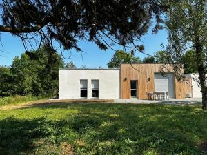 uma casa numa encosta com uma árvore em Solesmes 72 em Solesmes