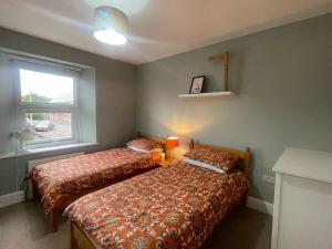 a bedroom with two beds and a window at Braunton Breaks - South Break House in Braunton