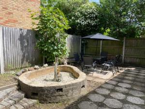 een kleine boom in een stenen fontein in een achtertuin bij 3-bedroom home with free parking in Canterbury