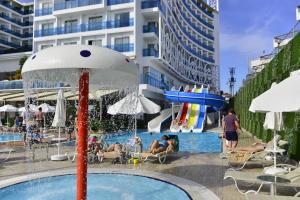 a pool with a water fountain in front of a building at Azura Deluxe Resort & Spa - Ultra All Inclusive in Avsallar