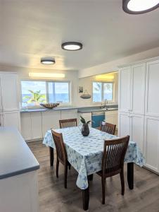 a kitchen with a table and chairs in a kitchen at Maka'Ala Lani - A view of Heaven in Keaau