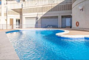 a large blue swimming pool in front of a building at VERANO AZUL in Benidorm
