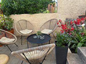 a patio with three chairs and a table and flowers at Luni in Zadar +6 photos
