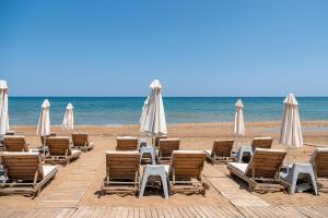 a group of chairs and umbrellas on a beach at Esperides Beach Hotel Apartments in Stalos