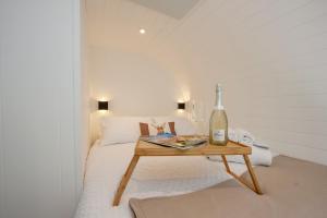 um quarto com uma cama com uma mesa com uma garrafa de vinho em The Stag, Luxury pod with hot tub, Croft4glamping em Oban