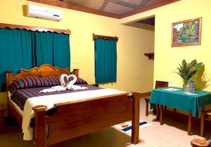 1 dormitorio con cama de madera y mesa con sidra de mesa en Crystal Paradise Resort, en San Ignacio