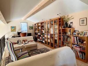 ein Wohnzimmer mit einem Sofa und Bücherregalen in der Unterkunft Villa et piscine au jardin typique méditerranéen in Carros