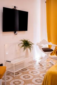 uma sala de estar com uma televisão pendurada numa parede em Mausida Guest House em Lido di Ostia