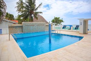 a blue swimming pool with a view of the ocean at Magico Apartamento Frente al Mar 3 Habitaciones B21 in Coveñas +23 photos