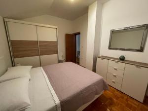 - une chambre avec un grand lit et un miroir dans l'établissement Apartman Josipa, à Biograd na Moru