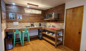 a kitchen with wooden walls and a counter with green stools at Hotel Chagual in La Serena