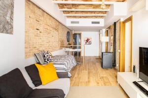 a living room with a couch and a brick wall at Sweet Room Barcelona in Hospitalet de Llobregat