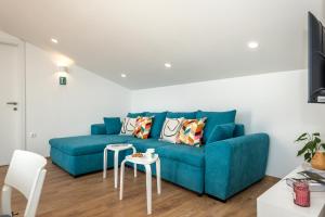 a living room with a blue couch and two tables at ABI Attic Apartment in Šibenik