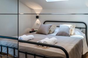 a bed with pillows on it in a room at ABI Attic Apartment in Šibenik