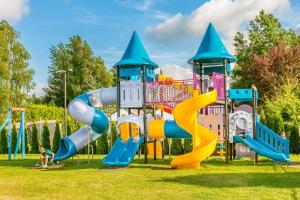 a playground with a slide and a play structure at Duet in Karwia