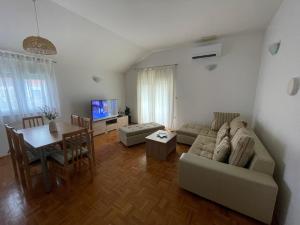 - un salon avec un canapé et une table dans l'établissement Apartman Josipa, à Biograd na Moru