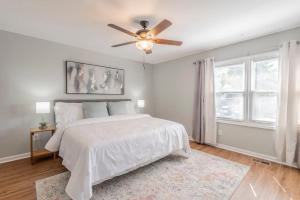 a white bedroom with a bed and a ceiling fan at Rocket City Retreat- Mins to everything in Huntsville