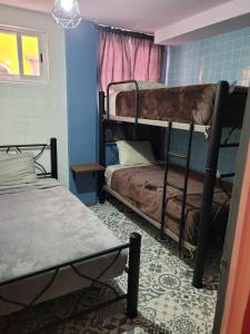 a room with two bunk beds in a room at Mala Vecindad Centro Historico in Mexico City