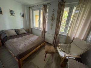 um quarto com uma cama, uma cadeira e janelas em Kasprusie 10 by Homeprime em Zakopane