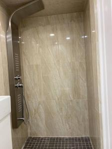 um chuveiro na casa de banho com piso em azulejo em Entire Basement with 3 Bedrooms em Cataratas do Niágara