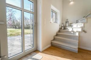 una escalera en una casa con una puerta corredera de cristal en Bi de Bark, en Fehmarn