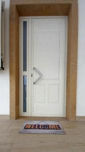 een welkomstmat voor een witte deur bij Casa Framaibla - la veranda sull'Etna in Augusta