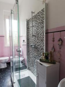 a pink bathroom with a shower and a sink at Appartamento Nautes in San Benedetto del Tronto