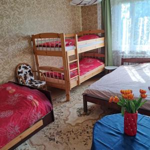 a bedroom with two bunk beds and a table at Jaama Puhkemaja in Puka