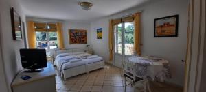 a bedroom with a bed and a desk with a television at Villa Playa del Sol - B2 in Saint-Tropez