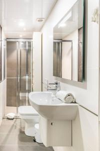 La salle de bains blanche est pourvue d'un lavabo et de toilettes. dans l'établissement Sweet Room Barcelona, à L'Hospitalet de Llobregat