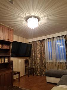 sala de estar con TV y lámpara de araña en Jaama Puhkemaja en Puka