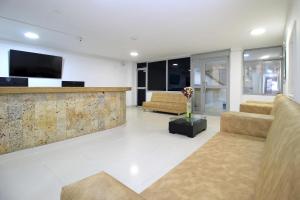 a living room with two couches and a tv at Hotel Rodadero Inn By GEH Suites in Santa Marta