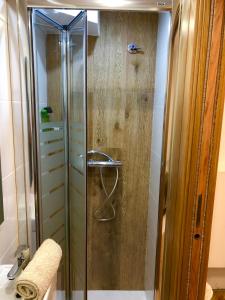 La salle de bains est pourvue d'une douche avec une porte en verre. dans l'établissement Sweet Room Barcelona, à L'Hospitalet de Llobregat