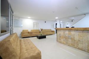 a lobby with couches and a bar in a building at Hotel Rodadero Inn By GEH Suites in Santa Marta