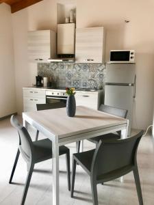 een keuken met een tafel en stoelen bij Appartamenti Villafiorito in Lazise