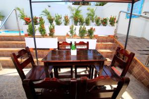 a table and chairs with potted plants on a wall at Hotel Rodadero Inn By GEH Suites in Santa Marta
