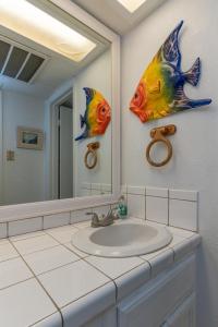 een badkamer met een wastafel en een grote spiegel bij Tiki 224 in South Padre Island