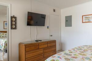 een slaapkamer met een dressoir en een flatscreen-tv aan de muur bij Tiki 224 in South Padre Island