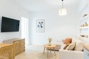 a white living room with a couch and a table at Propela apartments in Božava