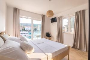 a bedroom with a large bed and a large window at Propela apartments in Božava