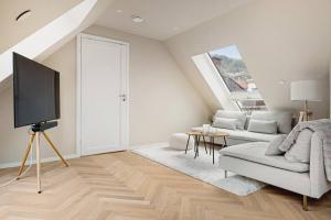 - un salon avec un canapé et une télévision dans l'établissement Dinbnb Apartments I Mid-City Luxury with Mini Balcony and Smart TV & Sound System, à Bergen