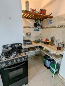 cocina con fogones y fregadero en Casa Bautista Apartamentos Amoblados con vista al mar en Taganga