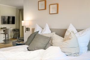 Schlafzimmer mit einem Bett mit weißer Bettwäsche und Kissen in der Unterkunft Op de Düün in Fehmarn