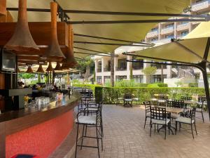 ein Restaurant mit Tischen und Stühlen und eine Bar in der Unterkunft ROYAL BEACH & APARTAMENT in Sonnenstrand