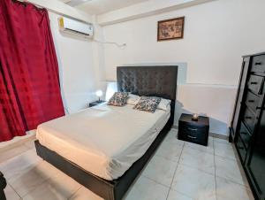 1 dormitorio con 1 cama con cortina roja en Casa Bautista Apartamentos Amoblados con vista al mar, en Taganga