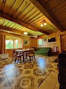 une salle à manger avec une table et un canapé vert dans l'établissement Žalioji, à Paduyelis