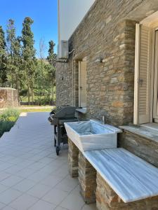 a stone building with a sink on a patio at The Secret Valley of Chora - 5 mins to Beach in Livádhia