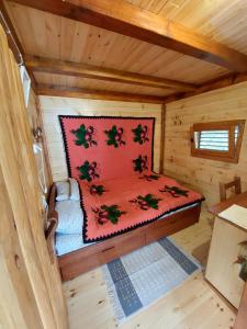 um pequeno quarto com uma cama num chalé de madeira em Seosko domaćinstvo Alababa em Kosjerić