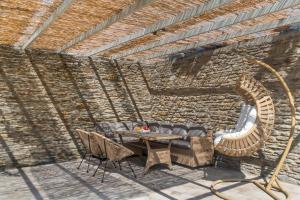 a patio with a table and chairs and a brick wall at The Secret Valley of Chora - 5 mins to Beach in Livádhia